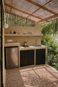 an outdoor kitchen with a sink and a pergola at Design Cabin with Plunge Pool in Ahangama
