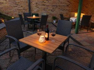 a wooden table with two glasses of wine on a patio at Zentrale Ferienwohnung am Bad Muskauer Park 2 Schlafzimmer Parkplatz Top Lage in Bad Muskau +33 photos