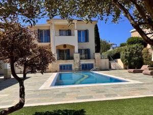 a villa with a swimming pool in front of a house at Beach villa Aurelia in Neo Chorio