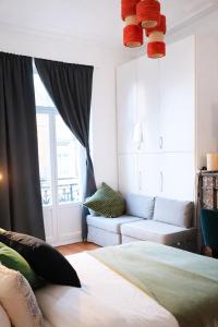 a bedroom with a bed and a couch and a window at Euro Edens Brussels - Family Home & Free Gym Access in Brussels