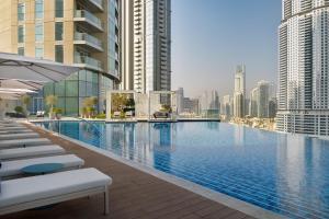 a large swimming pool in a city with tall buildings at Address Dubai Mall in Dubai