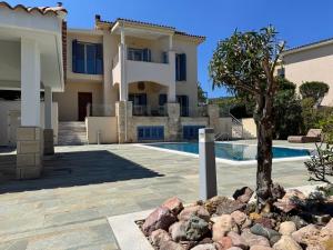 a villa with a swimming pool and a house at Beach villa Aurelia in Neo Chorio