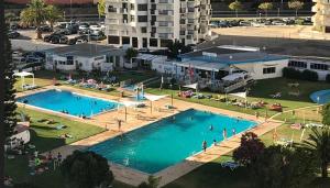an overhead view of a large swimming pool with people in it at 7C Castelo - Casas & Papeis in Armação de Pêra