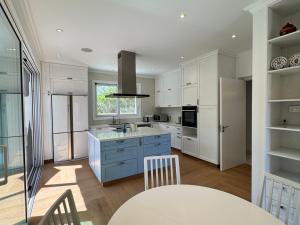 a kitchen with white cabinets and a table and chairs at Beach villa Aurelia in Neo Chorio