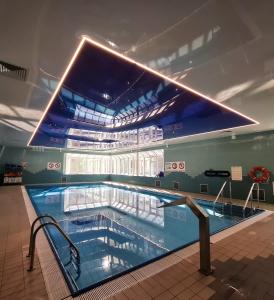 a swimming pool in a building with a large ceiling at San Medical Spa in Kołobrzeg