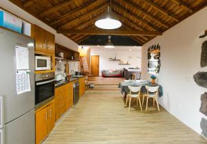 a kitchen and dining room with a table and chairs at Casa da Petra in Urzelina
