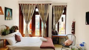 a bedroom with a bed in front of a window at Làng Kò Hơ hotel in Da Lat