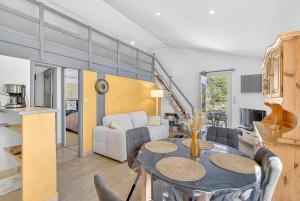 a kitchen and living room with a table and chairs at Location Gîte Les Iris in La Robine