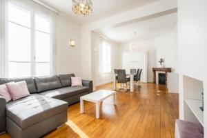 a living room with a couch and a table at Lys Appart in Reims