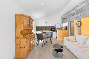 a kitchen and living room with a couch and a table at Location Gîte Les Iris in La Robine +18 photos