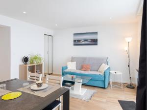 a living room with a blue couch and a table at Gites Au Point De Vue in Perros-Guirec