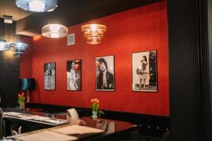 a red wall with pictures of women on it at Hotel Tarnovia in Tarnów +81 photos