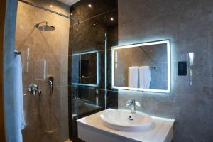 a bathroom with a sink and a shower with a mirror at Silverado Boutique Hotel in Tanga +31 photos