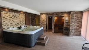a bathroom with a large tub and a kitchen at Hotel Magnific in Kranevo