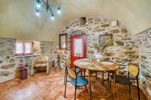 a dining room with a table and chairs in a stone wall at Mesaionas 1 in Olýmpoi