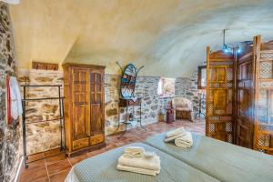a room with two beds and a stone wall at Mesaionas 1 in Olýmpoi