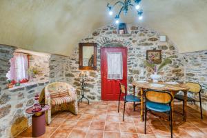 a room with a red door and a table and chairs at Mesaionas 1 in Olýmpoi +10 photos