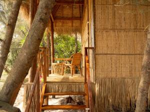 a tree house with a chair on the porch at Kactus - Your Island Sanctuary in Koh Ta Kiev