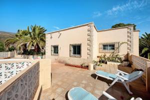 a patio with two chairs and a house at Finca El Pizarro in Arico