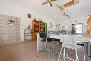 a kitchen with a counter and chairs in a room at Finca El Pizarro in Arico