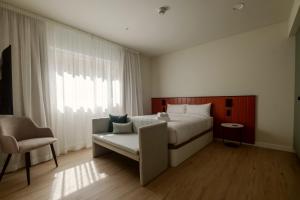 a bedroom with a bed and a chair and a window at Flipco Retiro in Madrid