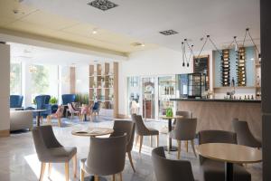a restaurant with tables and chairs and a bar at San Medical Spa in Kołobrzeg