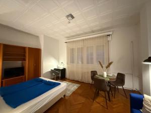 a bedroom with a bed and a table and chairs at Buda Blue in Budapest
