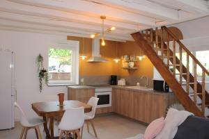a kitchen with a table and a kitchen with a staircase at Gîtes La Grenouillère in Veuzain-sur-Loire