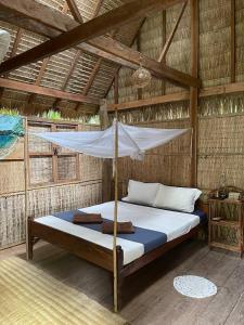 a bed with a mosquito net in a room at Kactus - Your Island Sanctuary in Koh Ta Kiev