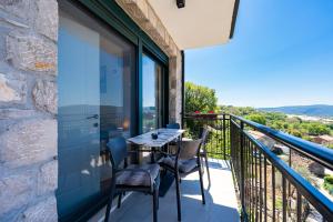 a patio with a table and chairs on a balcony at Dream View Villa in Kotor