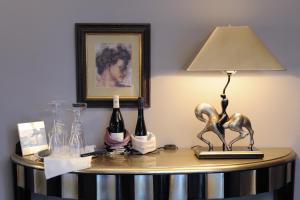 a table with a lamp and wine bottles on it at Jugendstil-Hof in Langenlonsheim
