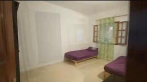 a room with two beds in a room with a window at Ali yessine in Al Maqārisah