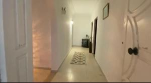 a hallway with a white door and a rug at Ali yessine in Al Maqārisah