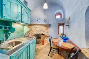 a kitchen with a table and a stone fireplace at Mesaionas 2 in Olýmpoi