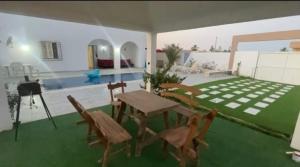 a room with a table and chairs and a green floor at Ali yessine in Al Maqārisah