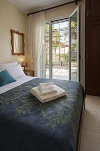 a bed with a towel sitting on top of it at Asterias in Koronisía