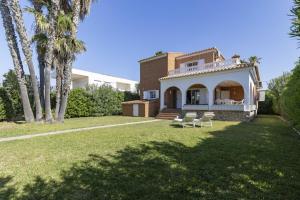 a house with two chairs in a yard at Beachfront Rental Home & Sea Views by Invalencia in Sagunto