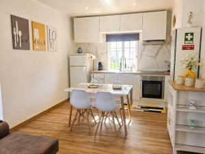 a kitchen with a table and chairs in a room at Vila de Baixo in Lajes das Flores