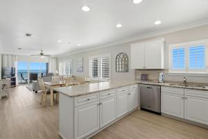 a kitchen with white cabinets and a dining room at Marlin Key 2A in Orange Beach