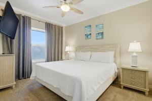 a bedroom with a white bed and a window at Marlin Key 2A in Orange Beach +49 photos