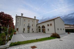a large white building with a courtyard in front of it at Villa Bido in Anguillara Veneta +23 photos