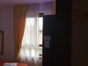 a bedroom with a window with a curtain at Magellano Room in Verona