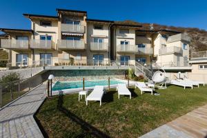 a building with a swimming pool and some chairs at EnjoyIseoLake - Lake View Paradise in Parzanica