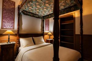 a bedroom with a four poster bed with a canopy at Le Logis des Seigneurs in La Flocellière