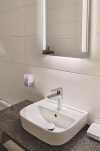 a white sink in a bathroom with a mirror at Bed and Breakfast am Höhenweg in Warstein +29 photos