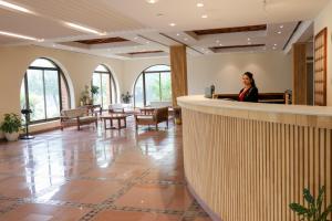 a woman sitting at a counter in a lobby at Hotel Lumbini Garden New Crystal in Rummindei