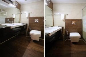 a bathroom with a sink and a toilet and a mirror at Rahitya Premier in New Delhi +24 photos
