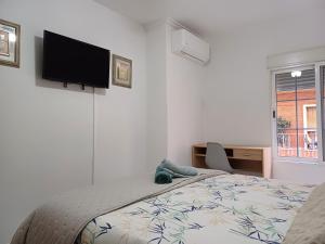 a bedroom with a bed and a flat screen tv on the wall at San Jose Luminoso in Algemesí