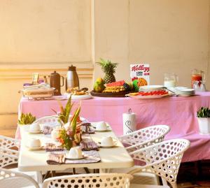 a pink table with chairs and food on it at Moshono WiDa Lodge in Arusha
