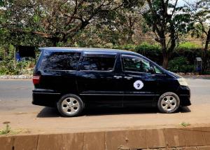 a black van parked on the side of a street at Moshono WiDa Lodge in Arusha